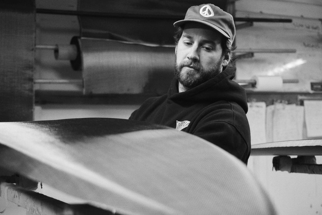 Mitch Hoakley reviewing his work on a carbon surfboard at the Luid Glassing Australia surfboard factory