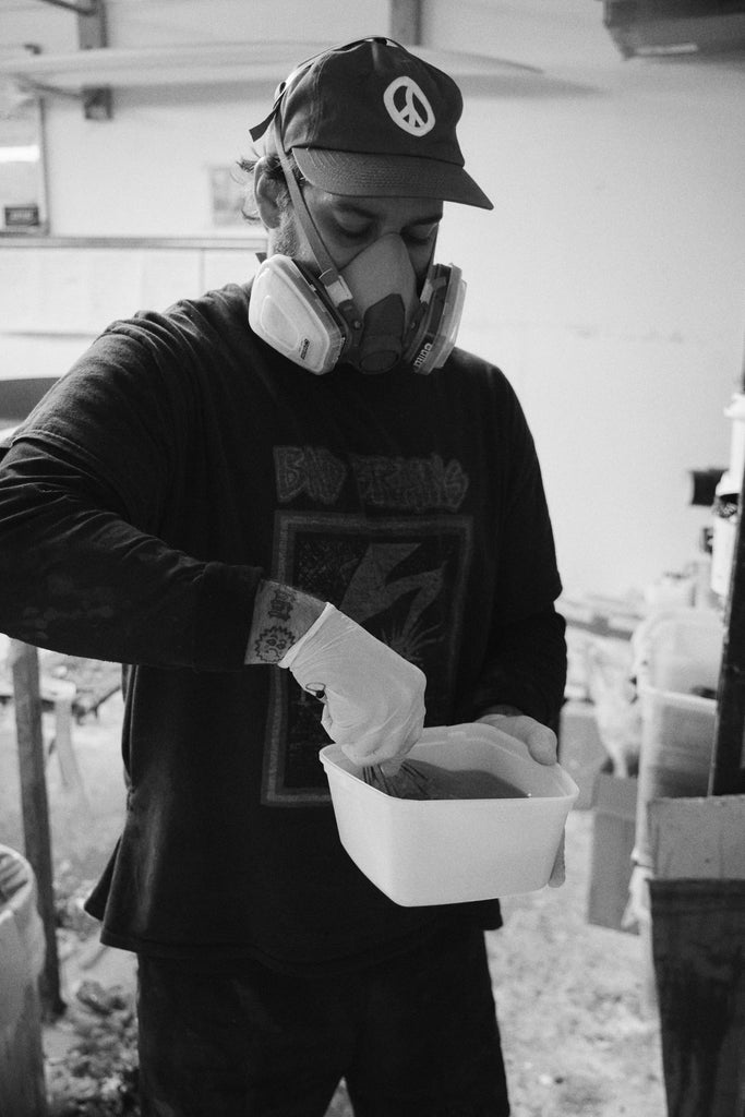 Mitch Hoakley mixing resin to glass a surfboard