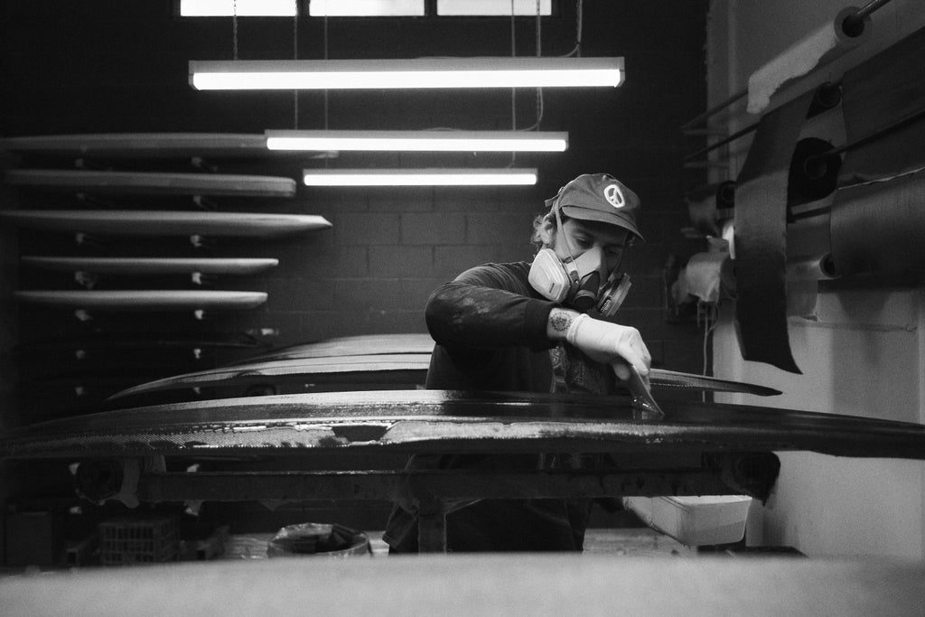 Mitch Hoakley glassing a carbon surfboard at Lucid Glassing Australia surfboard factory