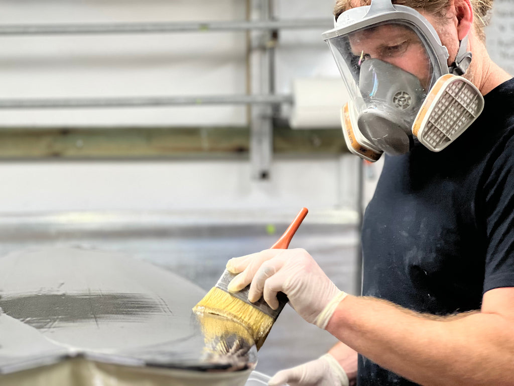 Amos Barriskill glassing a Dark Arts x Lucid Glassing collaboration carbon surfboard